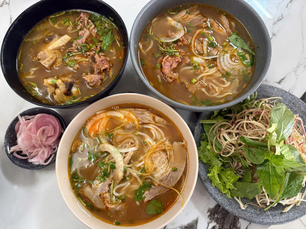 Các tô bún bò Huế Cây Khế với rau sống, hành ngâm chua và tỏi ngâm ăn kèm